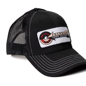 May include: Black trucker hat with a white patch that says "Cockshutt Farm Equipment" with a red and white logo in the center.
