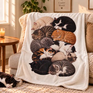 May include: A soft white fleece blanket featuring a large, central graphic print of ten cats of various breeds and colors, including tabby, calico, black, and orange, all curled up together in a cozy, stacked sleeping formation.