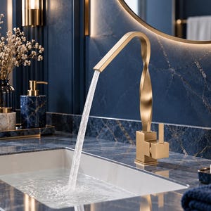 Puede incluir: Un grifo de baño en oro cepillado con un cuello retorcido en forma de espiral y una manija de palanca única, que dispensa un flujo constante de agua en un lavabo rectangular blanco sobre una encimera de mármol azul oscuro.