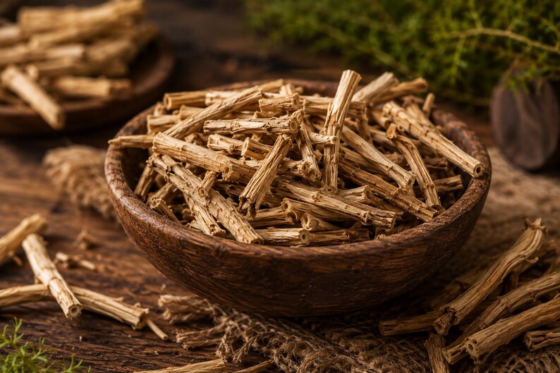 May include: A wooden bowl filled with dried, light brown asparagus stems. The bowl sits on a wooden surface, with additional asparagus stems scattered around. The image has a warm, natural aesthetic, suggesting a focus on organic ingredients.