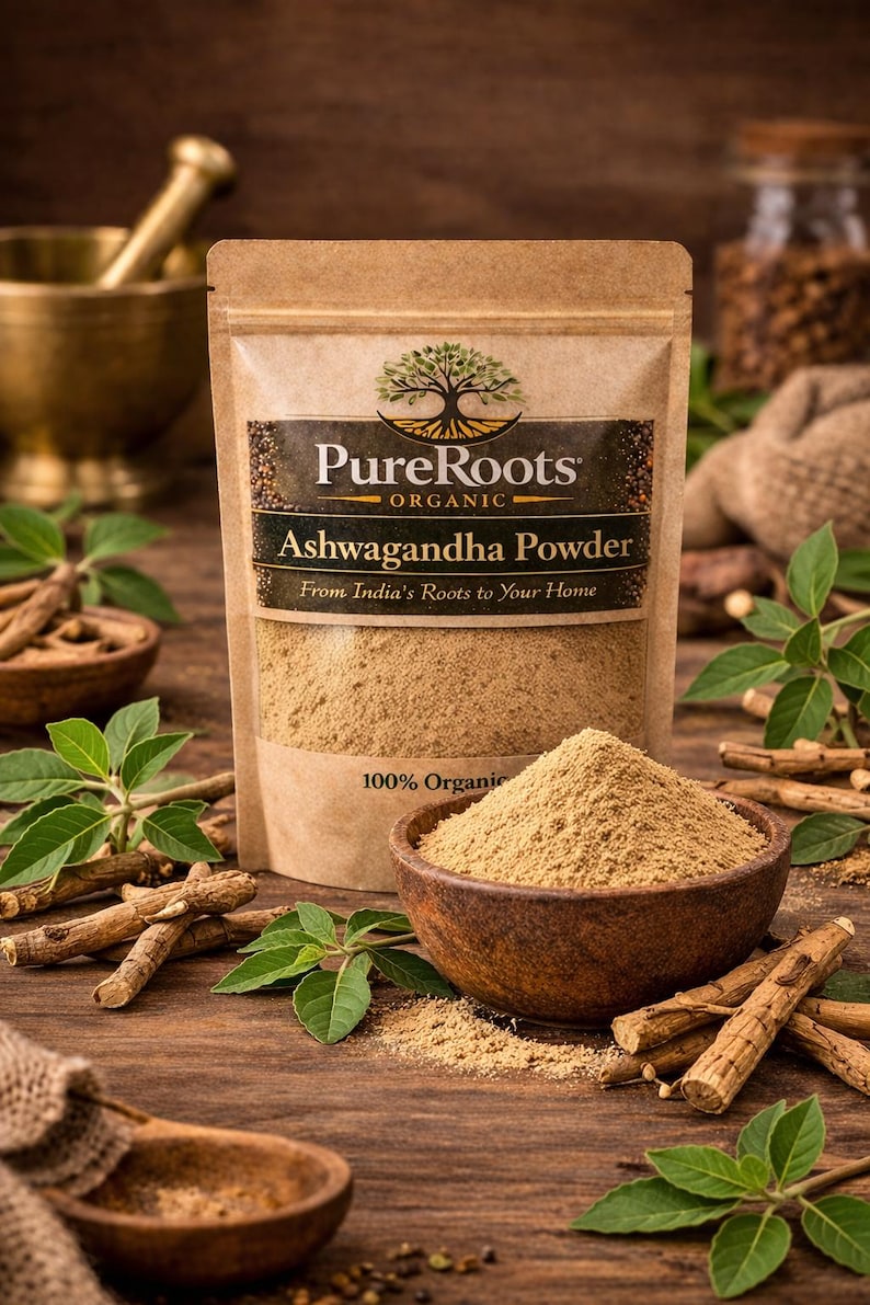 May include: A brown paper bag of "PureRoots" organic Ashwagandha powder, with a wooden bowl filled with the powder. Ashwagandha roots and green leaves are scattered around the bowl on a wooden surface. The text "From India's Roots to Your Home" is visible.