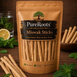 May include: A brown paper pouch containing Miswak sticks, labeled with the PureRoots Organic logo, a tree icon, and the text 'From India's Roots to Your Home'. The packaging features icons for 100% natural, premium quality, and no preservatives.