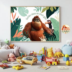 May include: A framed print featuring a cartoon orangutan and a bird, set against a backdrop of tropical leaves. The text "Schön dass es Dich gibt" is visible. The artwork is surrounded by children's toys.