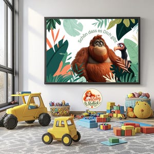 Könnte beinhalten: Ein gerahmter Druck mit einem Cartoon-Orang-Utan und Vogel, der Text lautet "Schön dass es Dich gibt", vor tropischen Blättern. Der Raum zeigt gelbe Spielzeug-LKWs, Bausteine und einen Teddybären, was einen Kinderspielbereich schafft.