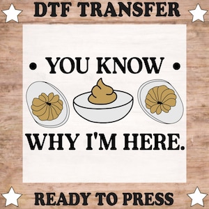May include: A DTF transfer ready to press featuring the text YOU KNOW WHY I'M HERE in black capital letters. The design includes three illustrations of deviled eggs with white egg whites and tan yolks, arranged horizontally between the lines of text.