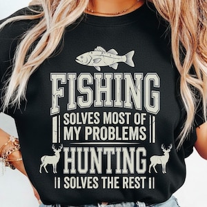 Può includere: T-shirt girocollo nera con la scritta "FISHING SOLVES MOST OF MY PROBLEMS HUNTING SOLVES THE REST". La maglietta presenta una grafica di pesce sopra la parola "FISHING" e grafiche di cervi su entrambi i lati della parola "HUNTING".