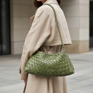Pode incluir: Uma bolsa de ombro verde em couro tran&ccedil;ado com uma al&ccedil;a tran&ccedil;ada. A bolsa tem um estilo macio e folgado e &eacute; usada no ombro. A bolsa &eacute; de cor verde suave e parece ser feita de couro de alta qualidade.
