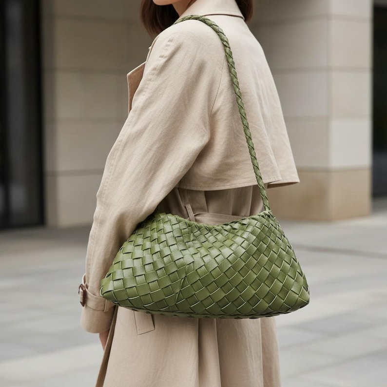 Pode incluir: Uma bolsa de ombro verde em couro tran&ccedil;ado com uma al&ccedil;a tran&ccedil;ada. A bolsa tem um estilo macio e folgado e &eacute; usada no ombro. A bolsa &eacute; de cor verde suave e parece ser feita de couro de alta qualidade.