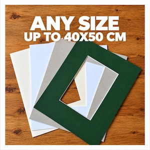 May include: A collection of rectangular paper picture mounts in white, cream, grey, and dark green, layered to show their centre cutouts. The text ANY SIZE UP TO 40X50 CM is printed in white at the top of the image, indicating available dimensions.