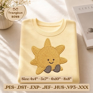 May include: A light yellow sweatshirt with a smiling sun design embroidered on the front. The sun has a happy face and gray feet. The text "Size: 4x4" - 5x7" - 6x10" - 8x8"" is below the design.