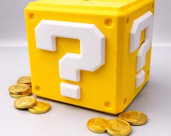 May include: A yellow question mark block with white question mark details, inspired by a video game. Gold coins are scattered around the block, suggesting a treasure theme. The block has a slot on top, indicating it's a bank or storage container.
