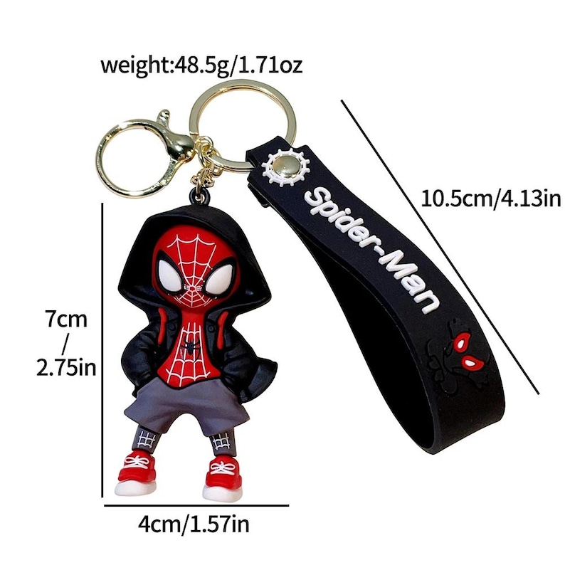 Może przedstawiać: Brelok do kluczy Spider-Man z czerwoną i czarną figurką z kapturem, czerwonymi trampkami i szarymi spodniami. Brelok zawiera czarny pasek z napisem "Spider-Man". Figurka ma 7 cm wysokości i 4 cm szerokości.