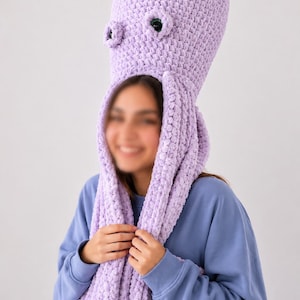 May include: A lilac crocheted octopus hat with large, round eyes and long tentacles. The hat covers the head and extends down the neck, creating a whimsical and playful look. The soft, textured yarn adds to the hat's unique appeal.