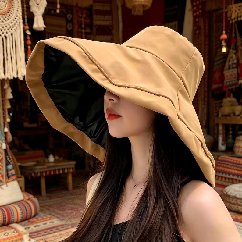 Puede incluir: Un sombrero de sol beige con ala ancha y forro interior negro. El sombrero tiene un dise&ntilde;o estructurado con ala ligeramente curvada. El sombrero est&aacute; hecho de un material suave y es adecuado para la protecci&oacute;n solar. Es un accesorio de moda.