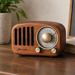 May include: A vintage-style wooden radio with a brass-colored dial and knobs. The radio has a speaker grill on the left side and the text "fm radio..." is printed on the front. The dial displays FM radio frequencies.
