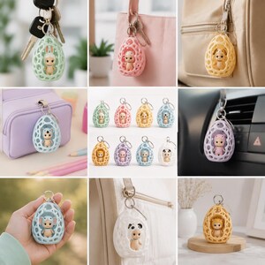 K&ouml;nnte beinhalten: Eine Sammlung farbenfroher Schl&uuml;sselanh&auml;nger mit Tierfiguren in eif&ouml;rmigen, durchbrochenen Designs. Die Schl&uuml;sselanh&auml;nger sind in verschiedenen Farben erh&auml;ltlich, darunter Gr&uuml;n, Rosa, Gelb und Blau, mit Tieren wie Hase, B&auml;r und Panda. Jeder Schl&uuml;sselanh&auml;nger hat einen silbernen Schl&uuml;sselring.