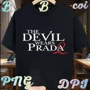 May include: Black t-shirt with the text "THE DEVIL WEARS PRADA 2" in white and red. The shirt has a crew neck and short sleeves. The design is centered on the front of the shirt.