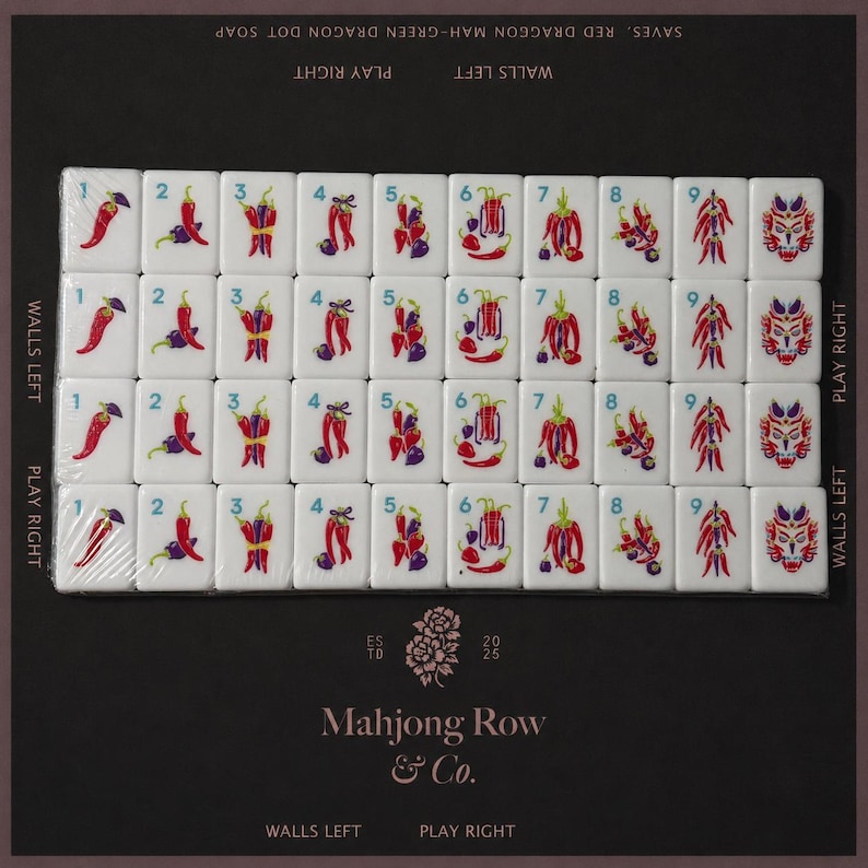 May include: A set of white mahjong tiles arranged in a grid, featuring colorful chili pepper illustrations numbered one through nine and a dragon face design. The packaging includes the text Mahjong Row & Co. and various directional labels.