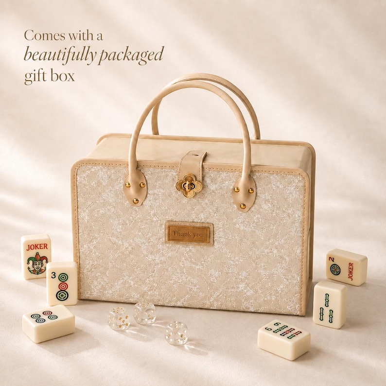 May include: A rectangular beige carrying case with two top handles and a central gold-toned clover-shaped clasp. The front features a textured pattern and a rectangular patch with the text Thank you. Several mahjong tiles and dice are nearby.