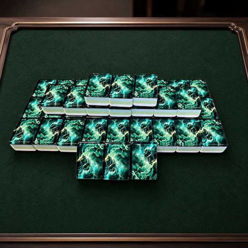 Peut inclure: Un ensemble de tuiles de mah-jong rectangulaires dispos&eacute;es en grille. Chaque tuile pr&eacute;sente un motif vibrant rappelant une n&eacute;buleuse, avec des nuances de bleu sarcelle profond, de vert &eacute;meraude et de blanc &eacute;clatant sur une base sombre.
