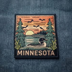May include: A rectangular embroidered patch featuring a loon swimming on a lake at sunset. The scene includes two tall green pine trees, a yellow sun, and birds flying in an orange sky. The word MINNESOTA is stitched in large letters at the bottom.