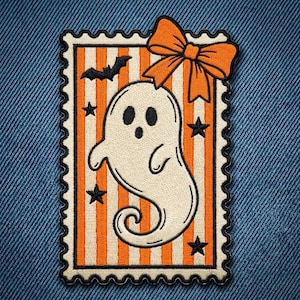 May include: A rectangular embroidered patch shaped like a postage stamp featuring a white ghost with a surprised expression, an orange bow at the top, and a background of vertical orange and white stripes decorated with black stars and a bat.