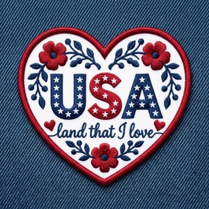 May include: A heart-shaped embroidered patch with a white background and red border. It features the text USA in blue and red with white stars, and the script text land that I love. The design includes red flowers and blue leafy branches.