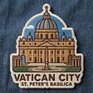 May include: An embroidered patch featuring St. Peter's Basilica in Vatican City. The design shows the tan building with a grey dome against a blue sky, with a central obelisk and green foreground. The text reads VATICAN CITY ST. PETER'S BASILICA.