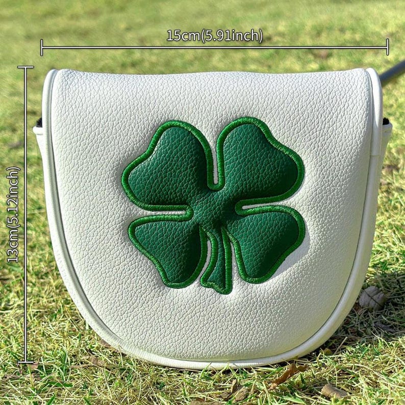 May include: A white mallet putter headcover featuring a large green four-leaf clover embroidery. The cover measures 5.91 inches in width and 5.12 inches in height. The textured white material contrasts with the bold green clover design.