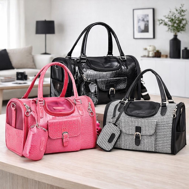 May include: Three pet carrier bags in black, pink, and black and white houndstooth patterns. The bags have top handles, small front pockets, and matching accessories. The pink bag has a crocodile texture.