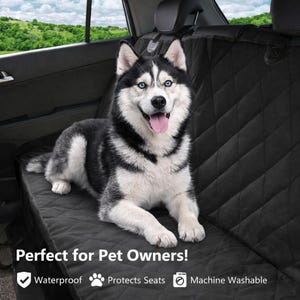 Puede incluir: Una funda de asiento de coche negra acolchada con un perro husky feliz. El perro tiene ojos azules y un pelaje blanco y negro. La funda es impermeable, protege los asientos y es lavable a máquina.