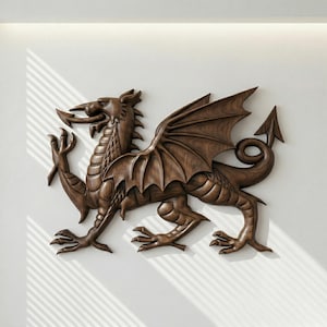 May include: A detailed, brown wooden dragon wall sculpture. The dragon has outstretched wings, a long tail with an arrow-shaped tip, and intricate carved details. The sculpture is mounted on a white wall, with shadows from a window.