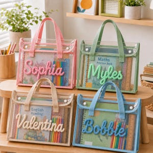 Op de afbeelding: Vier rechthoekige, doorzichtige plastic draagtassen met mesh-rand en stoffen handvatten. Elke tas is voorzien van een gepersonaliseerde naam in verhoogde, textuurrijke garenletters: Sophia in roze, Myles in groen, Valentina in crème en Bobbie in blauw.