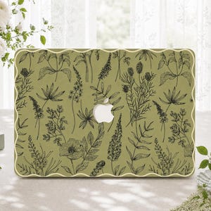 May include: A laptop skin featuring a muted olive green background with a repeating black line art pattern of various wildflowers, leaves, and stems. The design includes a central cutout for the Apple logo and a decorative scalloped edge.