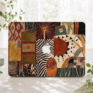 May include: A laptop skin featuring a collage of diverse patterns including zebra stripes, geometric shapes, a sunburst motif, and rectangular panels in shades of red, gold, green, and black, with a central cutout for the Apple logo.