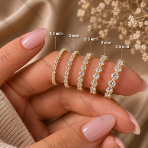 Op de afbeelding: Vijf gouden eternity-ringen met ronde stenen in verschillende maten. De ringen zijn gelabeld met afmetingen van 1,5 mm, 2 mm, 2,5 mm, 3 mm en 3,5 mm, wat de diameter aangeeft van de stenen die in de dunne metalen banden zijn gezet.