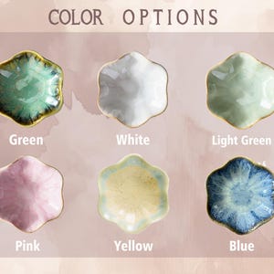 Op de afbeelding: Zes kleine keramische schaaltjes in groen, wit, lichtgroen, roze, geel en blauw. Elk schaaltje heeft een bloemvorm met een gouden rand. De tekst "COLOR OPTIONS" staat bovenaan.