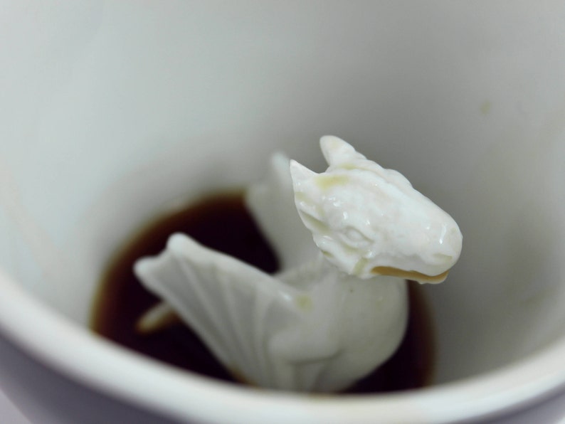 Closeup of the ceramic dragon at the bottom of the mug