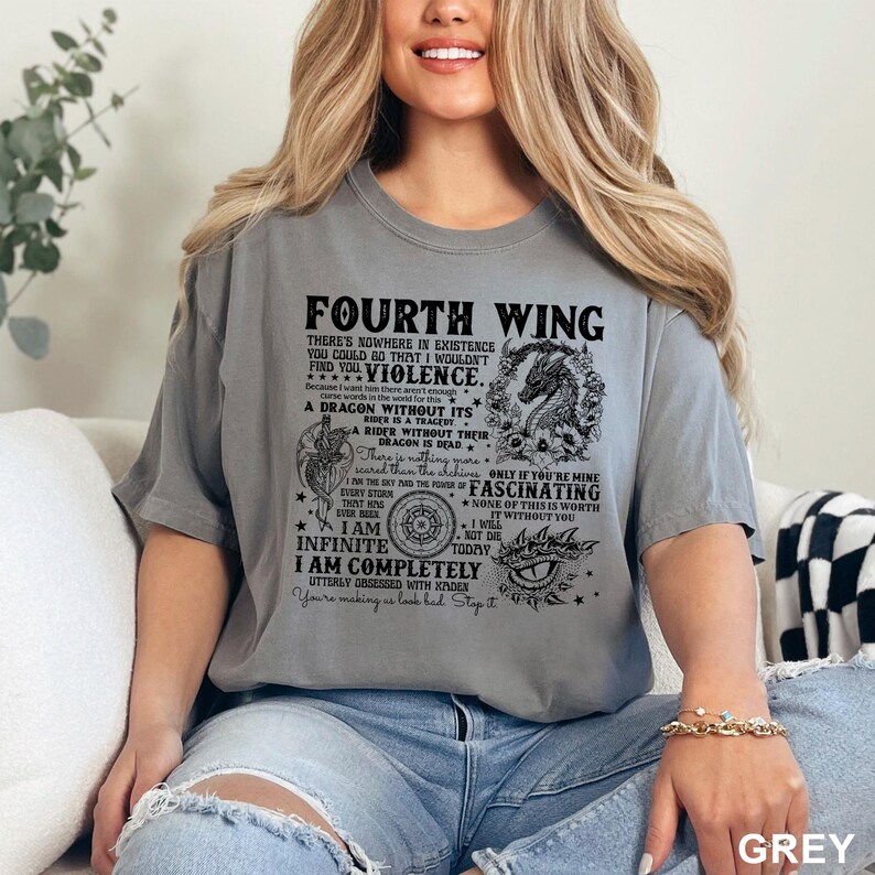 May include: Grey t-shirt with the text "FOURTH WING" and other text with dragon and eye graphics. The shirt has short sleeves and a crew neck.