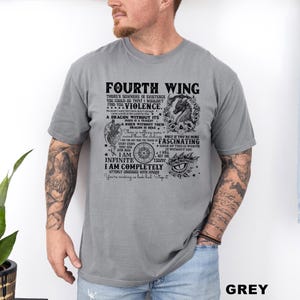 May include: Grey t-shirt with the text "FOURTH WING" and other text and graphics. The shirt features a dragon illustration and various phrases. The word "GREY" is printed at the bottom right.