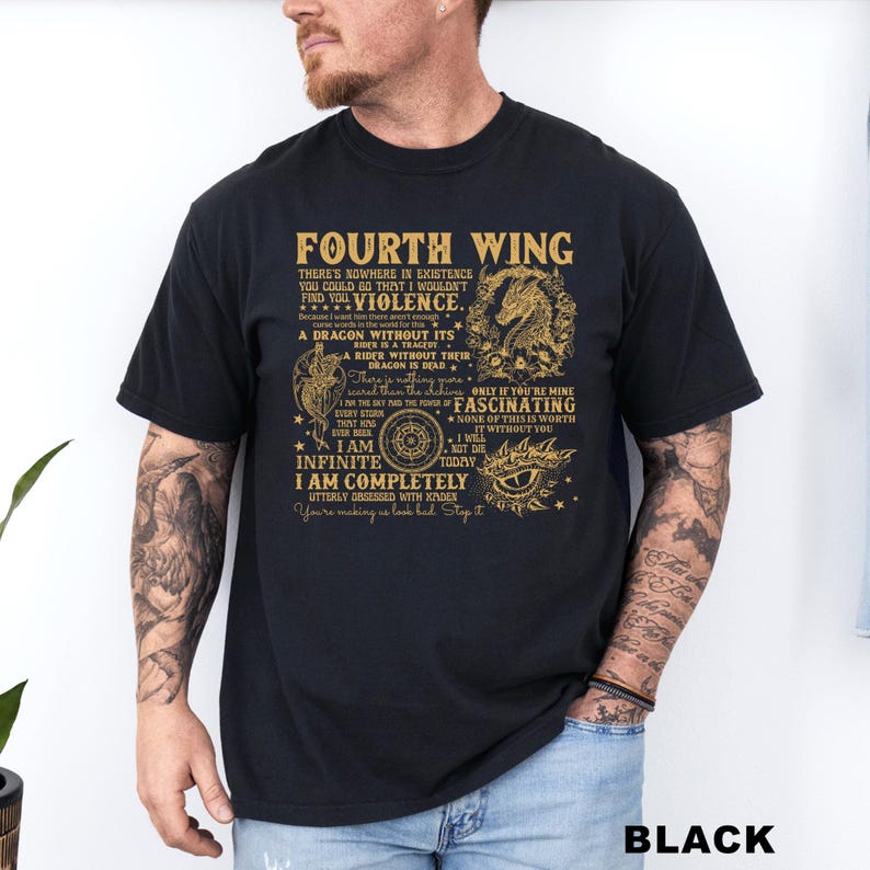 May include: Black t-shirt with gold text and graphics. The text reads "FOURTH WING" and includes phrases like "Violence," "A Dragon Without Its Rider Is A Tragedy," and "I Am Infinite." The shirt also features a dragon illustration.
