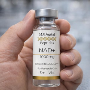 May include: A clear glass vial with a silver cap and a white label. The label reads MJDigital Peptides, a DNA helix icon, NAD+ 1000mg, Lot/Exp: 0425 MM/YY, For Research Only, and 3ml Vial. The label features gold horizontal bands at the top and bottom.