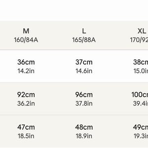 May include: A size guide table with measurements in centimeters and inches. The table includes sizes S to 3XL, with shoulder measurements ranging from 35cm (13.8in) to 40cm (15.7in), bust measurements from 88cm (34.6in) to 108cm (42.5in), and back lengths from 46cm (18.1in) to 51cm (20.1in).