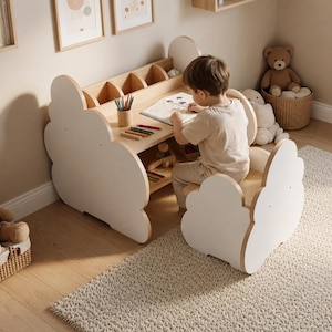Puede incluir: Un conjunto de escritorio y silla infantil en madera clara y blanco con paneles laterales en forma de nube. El escritorio incluye un organizador integrado con varios compartimentos para material de papelería y un estante inferior para almacenamiento.