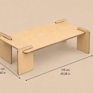 May include: A light-colored wooden table with a rectangular top and four flat legs. The table features visible joinery where the legs slot into the top. Dimensions are 15.75 inches high, 23.62 inches wide, and 45.28 inches long as indicated.
