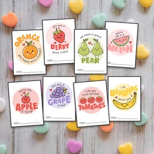 May include: Eight printable Valentine's Day cards featuring fruit puns. Each card has a different fruit with a cute face and a punny message. The fruits include an orange, a berry, a pear, a melon, an apple, a grape, a tomato, and a banana.