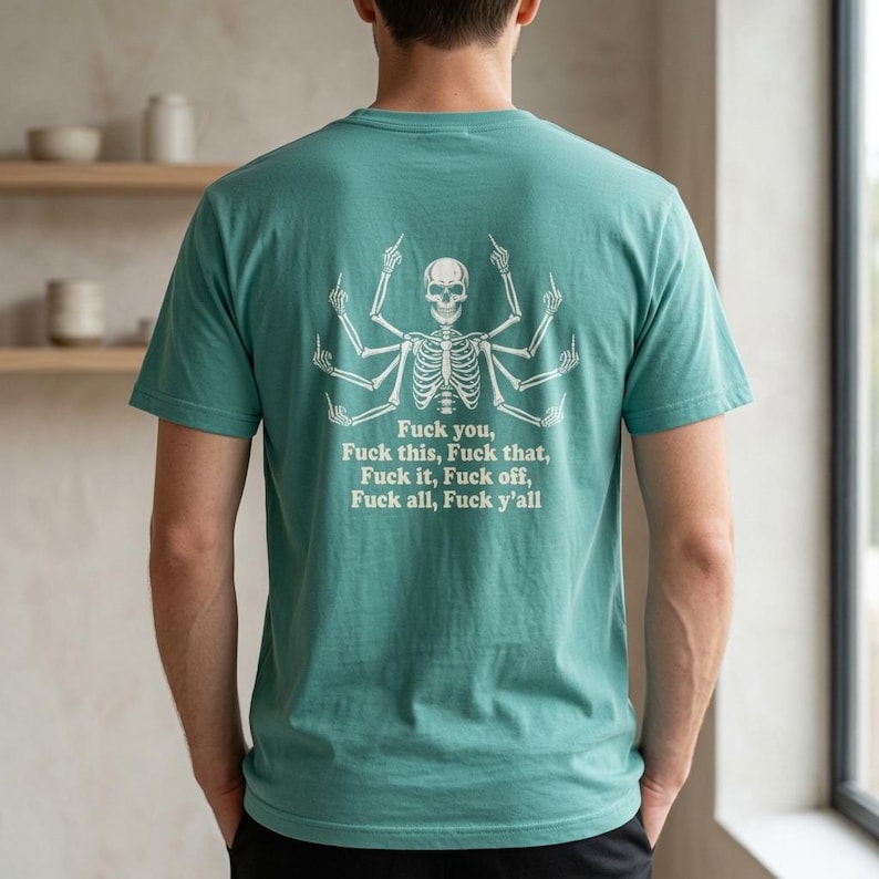 May include: A teal short-sleeved t-shirt featuring a white graphic on the back of a multi-armed skeleton giving the middle finger with every hand. Below the skeleton, the text reads: Fuck you, Fuck this, Fuck that, Fuck it, Fuck off, Fuck all, Fuck y'all.