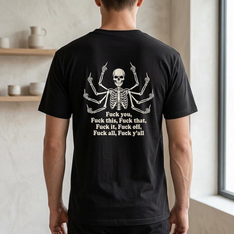 May include: A black short-sleeved t-shirt featuring a white graphic of a multi-armed skeleton giving the middle finger with each hand. Below the skeleton, the text reads: Fuck you, Fuck this, Fuck that, Fuck it, Fuck off, Fuck all, Fuck y'all.
