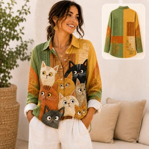 Puede incluir: Una camisa de manga larga con botones y un estampado gráfico colorido de varios gatos en tonos naranja, gris y negro. La camisa tiene cuello y cierre frontal de botones. Un recuadro muestra la parte posterior de la prenda.