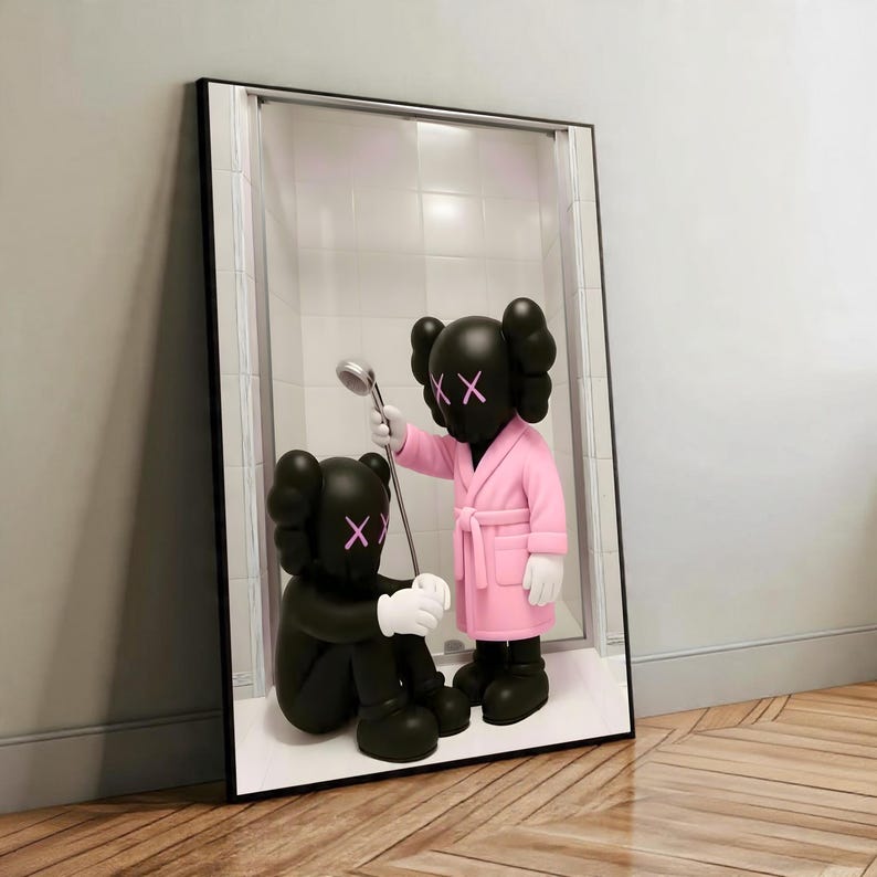 May include: Framed artwork featuring two black figures with X-shaped eyes. One figure sits, while the other, in a pink robe, holds a shower head. The background shows a shower stall with white tiles, set against a wooden floor.